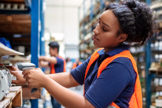 Female scanning a product with a barcode scanner in a warehouse