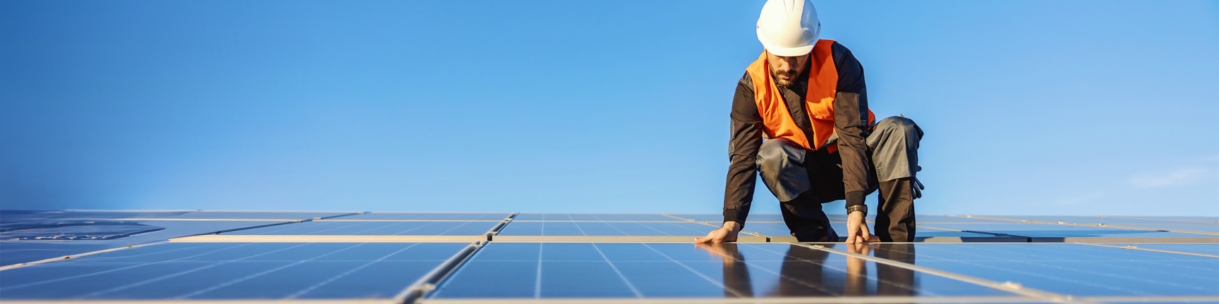 Man with hardhat on solar panels