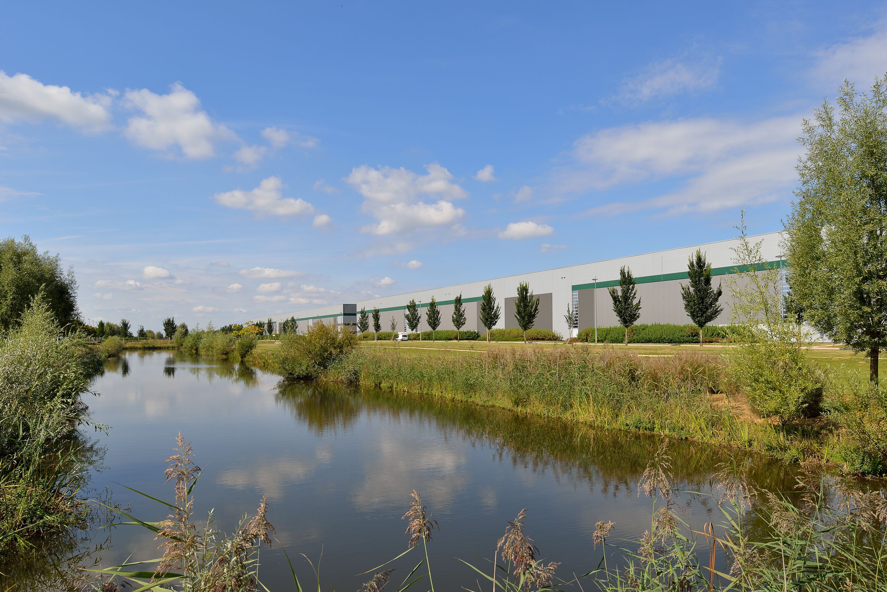 Ein Lagerhaus mit Bäumen und einem Fluss im Hintergrund